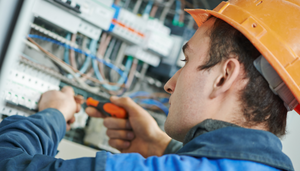 électricien qui travaille sur un tableau électrique